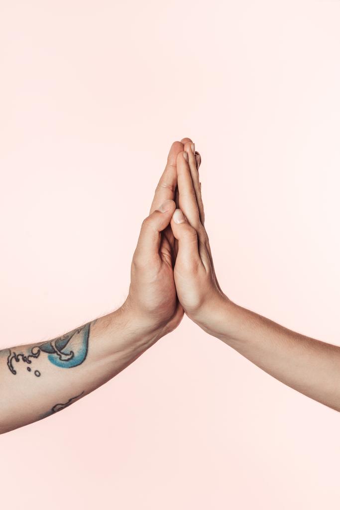 levágott lövés tetovált férfi és nő a gazdaság palms együtt elszigetelt rózsaszín háttér  - Fotó, kép