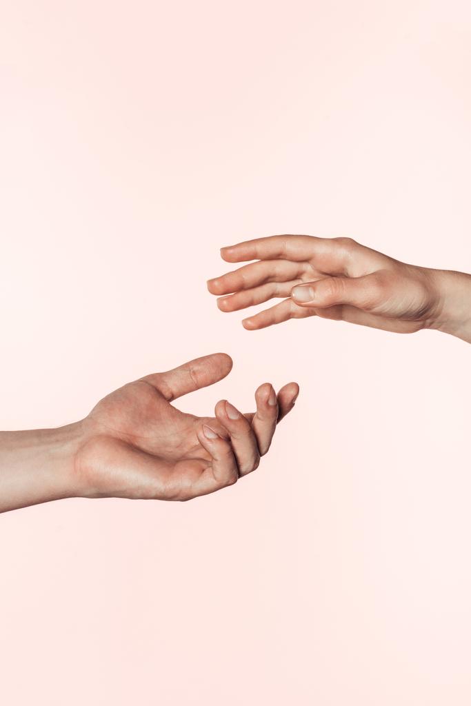女と男が手をピンクの背景に分離されて互いに近づいての部分的なビュー  - 写真・画像