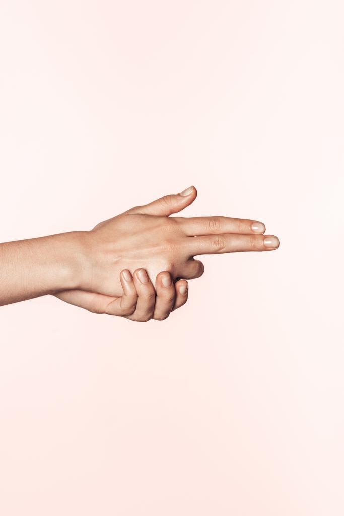 abgeschnittenes Bild weiblicher Hände in Form von Pistolen isoliert auf rosa Hintergrund - Foto, Bild