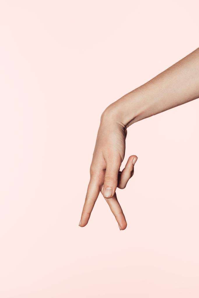 トリミングされた画像に分離、ピンクの背景を 2 本指でのジェスチャーを示す女性の - 写真・画像