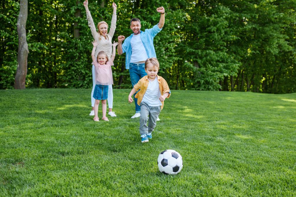 familia feliz jugando con la pelota de fútbol en el parque
 - Foto, imagen