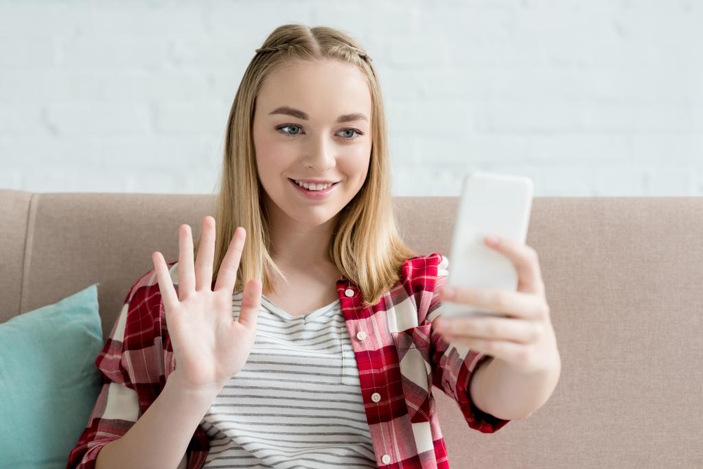 十代の学生の女の子のスマート フォンでビデオ通話とカメラに手を振ってのクローズ アップの肖像画 - 写真・画像