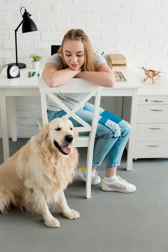 lächelndes Teenie-Mädchen verbringt Zeit zu Hause mit ihrem Hund - Foto, Bild