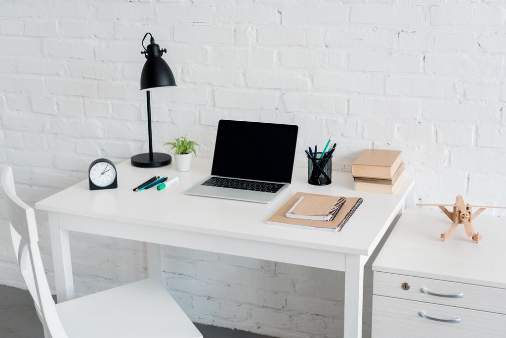 moderne werkplaats met laptop thuis voor witte bakstenen muur - Foto, afbeelding