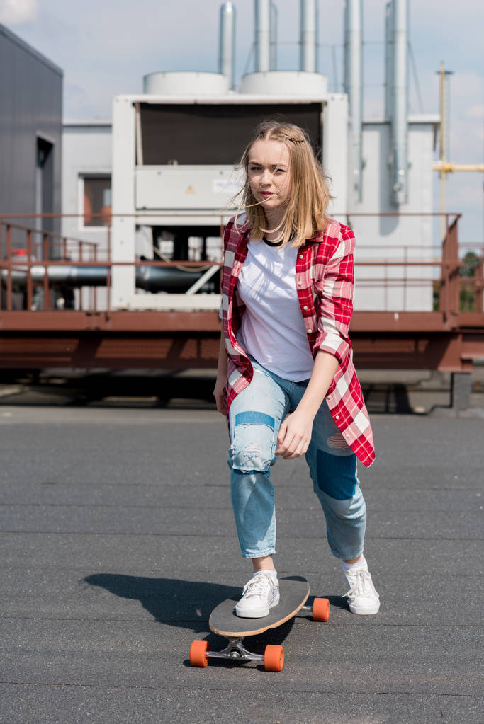 ativo adolescente menina equitação skate no telhado
 - Foto, Imagem