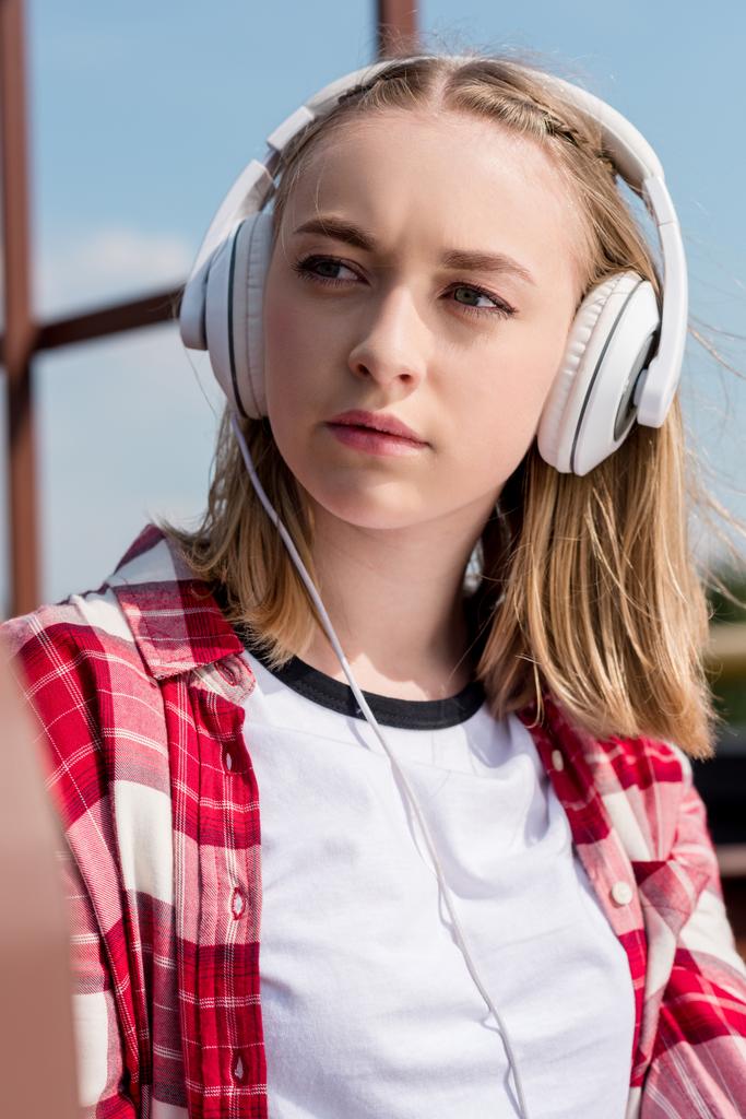 close-up portrait of teen girl in red plaid shirt and headphones  - Photo, Image