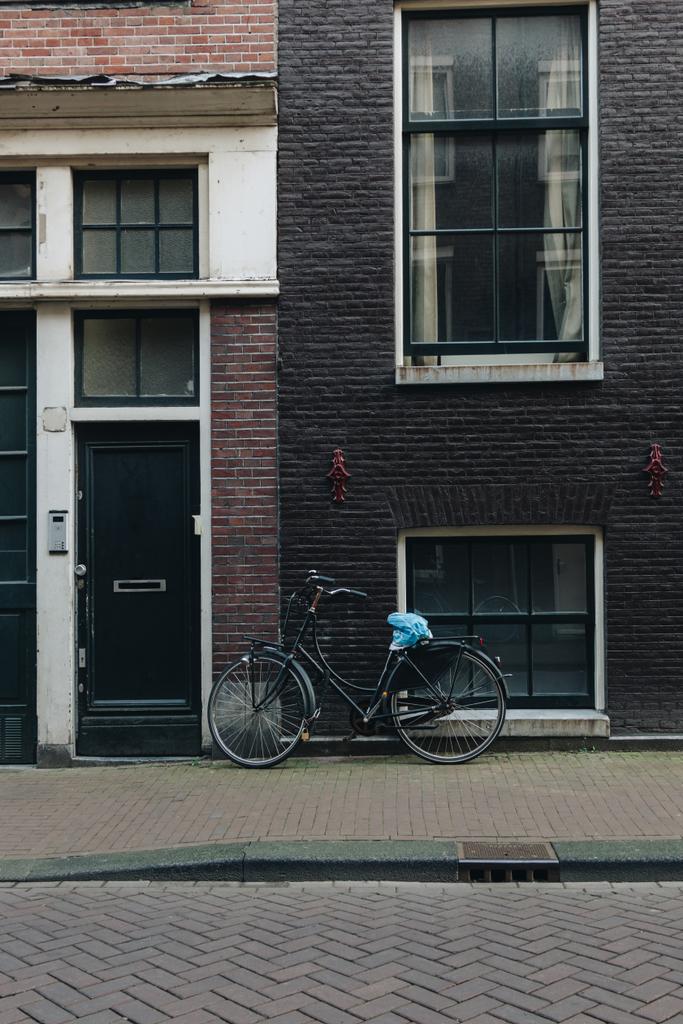 Fassade eines Altbaus mit abgestelltem Fahrrad, Amsterdam, Niederlande - Foto, Bild