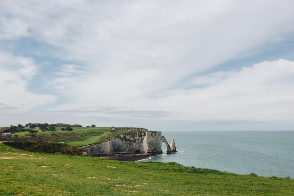 вид с высоты птичьего полета на зеленую скалу и голубое море, Этретат, Нормандия, Франция
 - Фото, изображение
