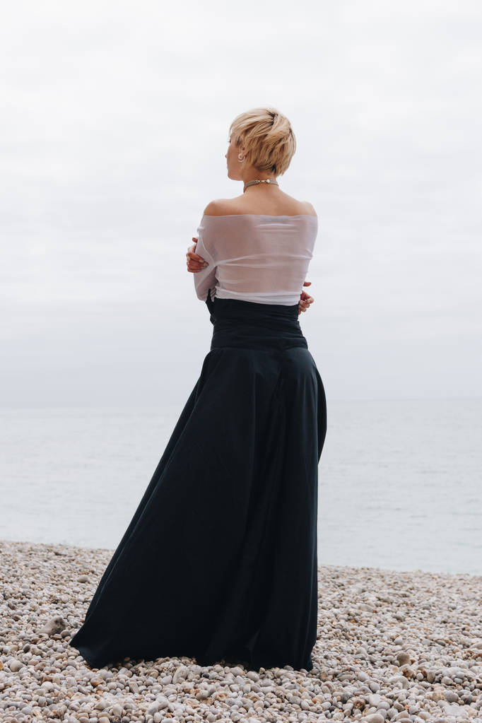 back view of stylish girl posing on shore near sea, Etretat, Normandy, France  - Photo, Image