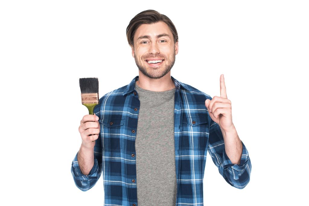 улыбающийся мужчина держит кисть и делает жест идеи изолирован на белом фоне
  - Фото, изображение