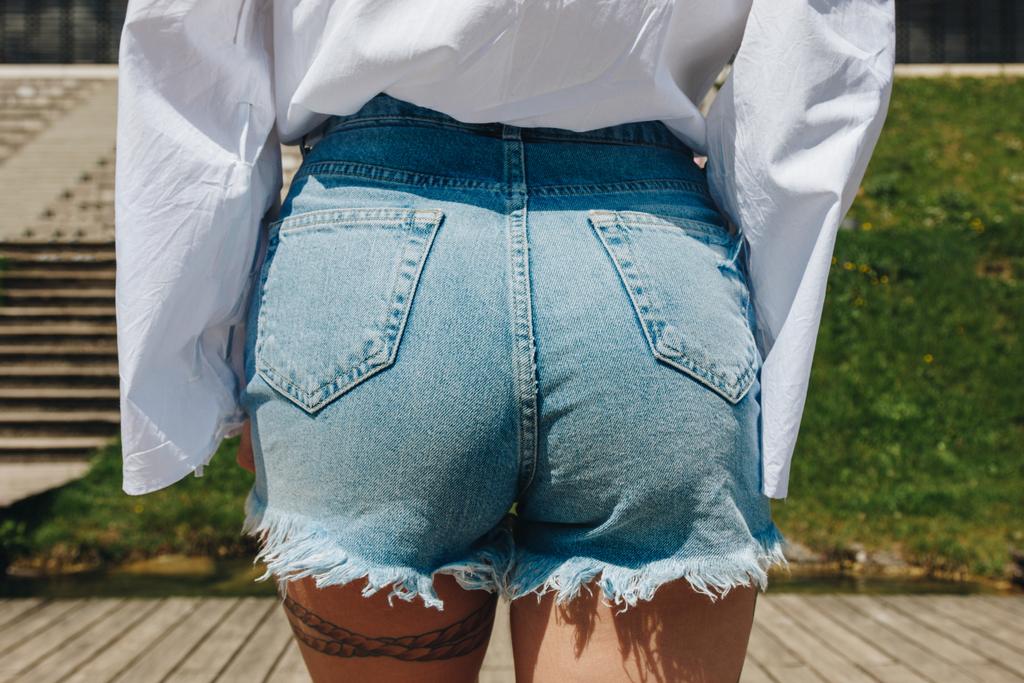 tiro cortado de belas nádegas femininas em shorts jeans elegantes
 - Foto, Imagem