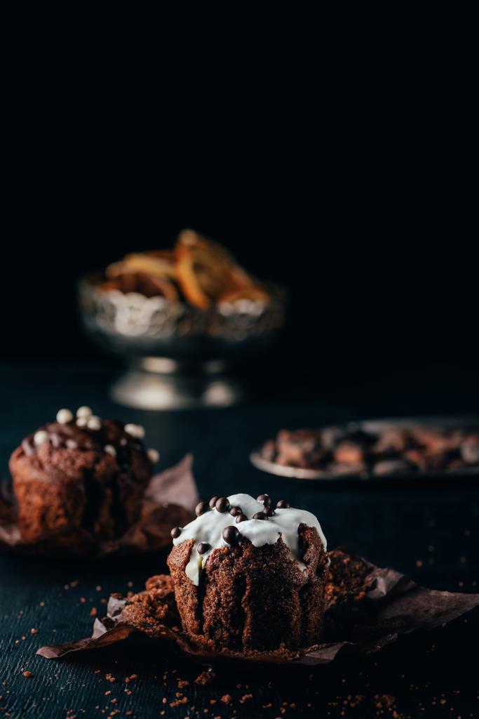 Édes cupcakes a csokoládé chips és édes máz, a sötét háttér - Fotó, kép