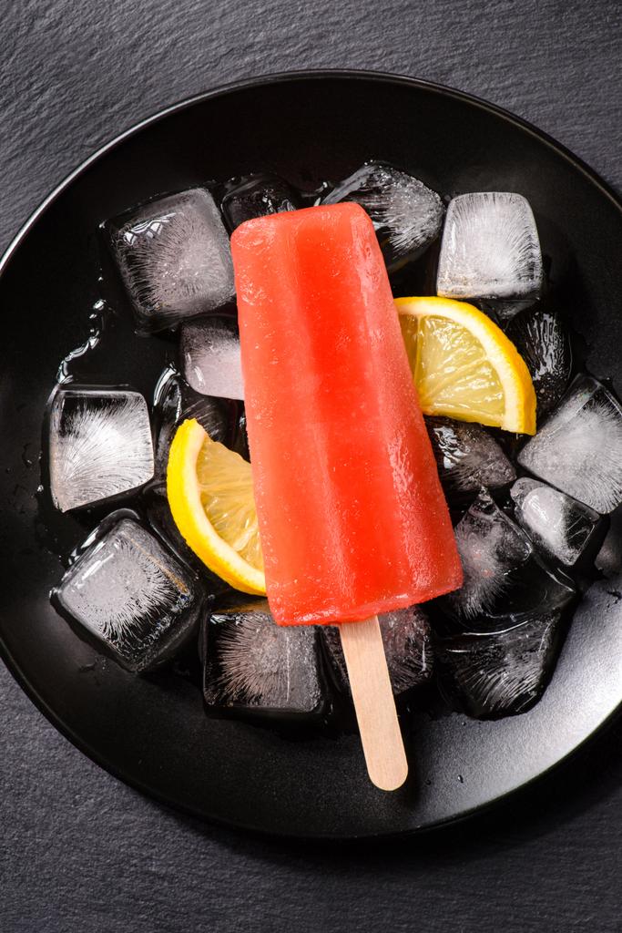 Delicious red popsicles on ice cubes with lemon - Photo, Image