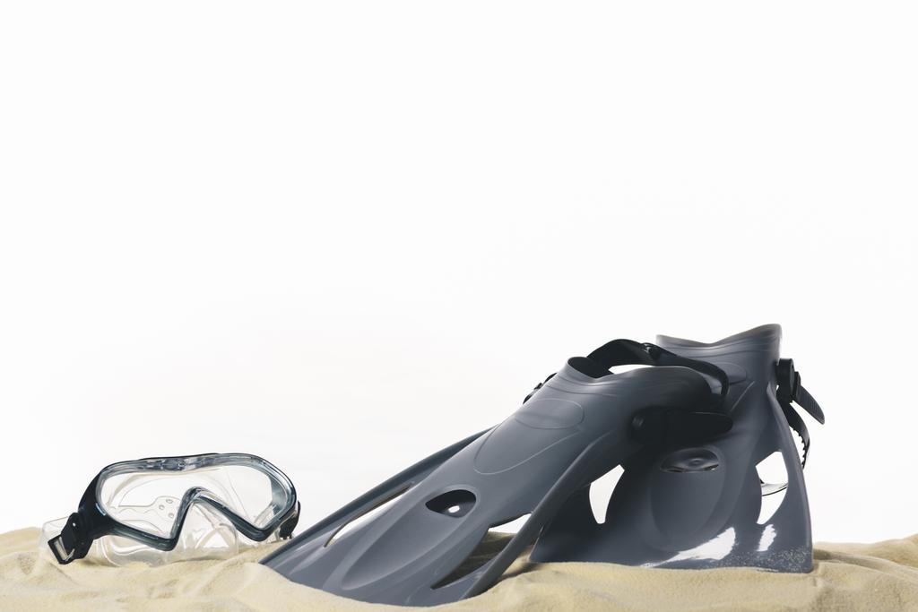 Masker en flippers in zand geïsoleerd op wit - Foto, afbeelding