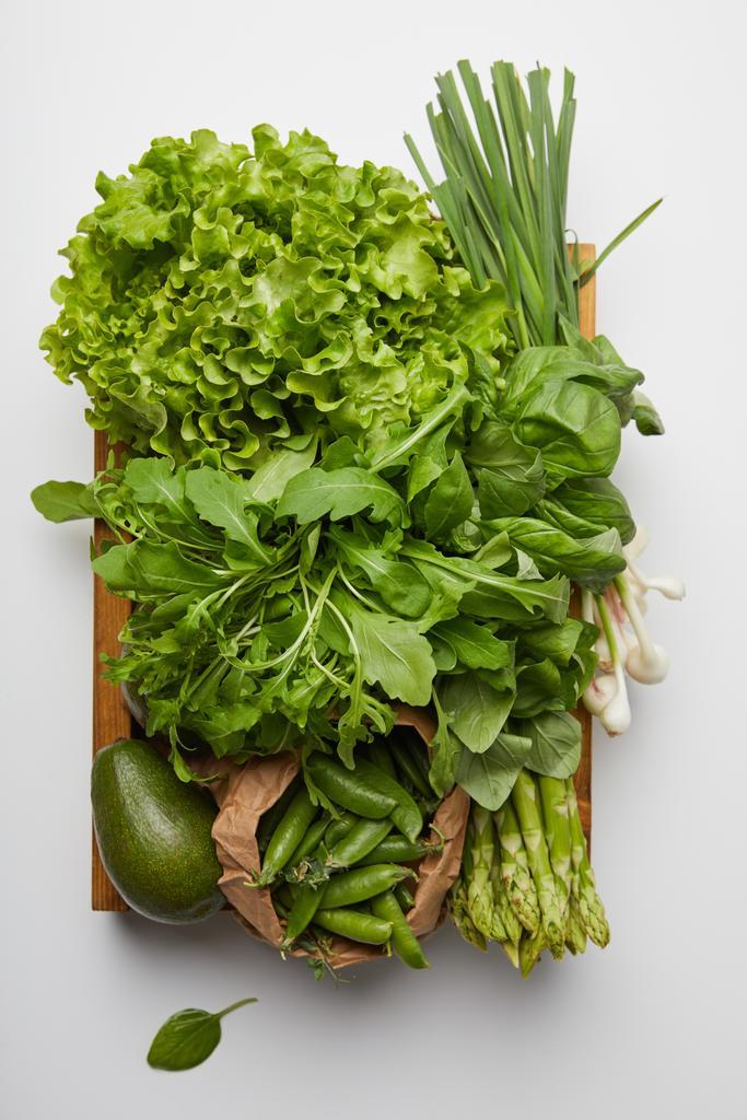 вид сверху на различные спелые овощи в коробке на белой поверхности
 - Фото, изображение