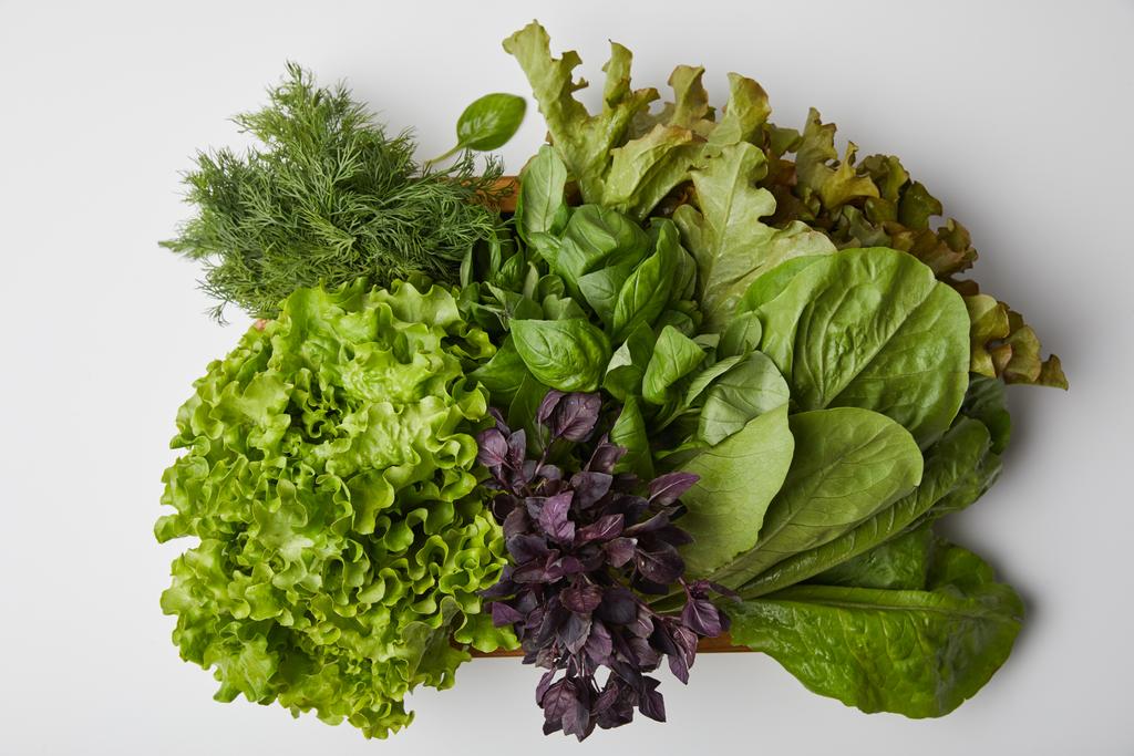 vue du dessus de divers légumes à feuilles mûres en boîte sur surface blanche
 - Photo, image