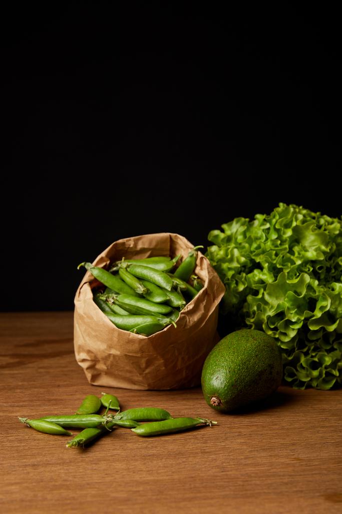 close-up shot of avocado, green peas and lettuce on wooden surface - Photo, Image