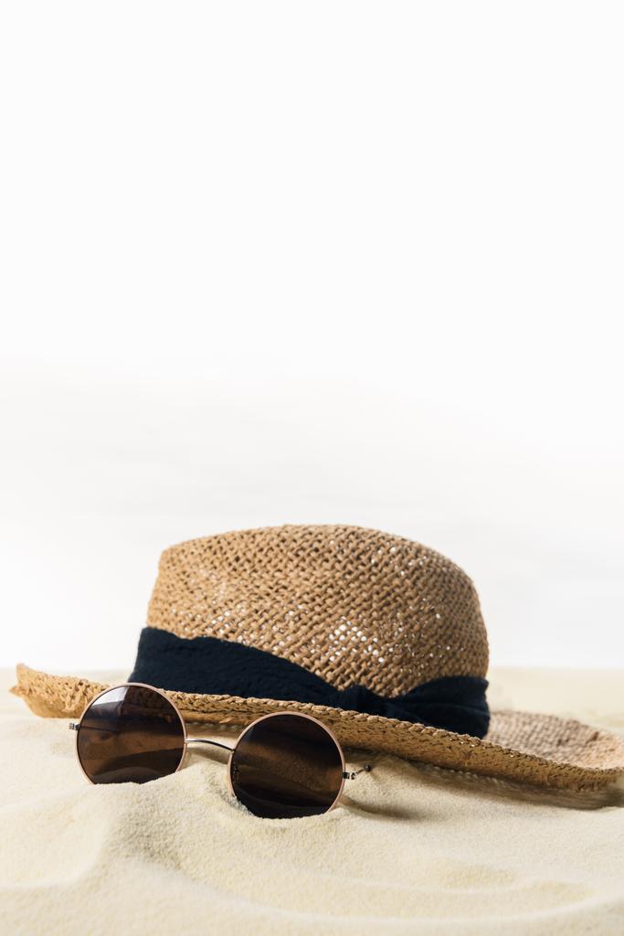 Straw hat and sunglasses in sand isolated on white - Photo, Image