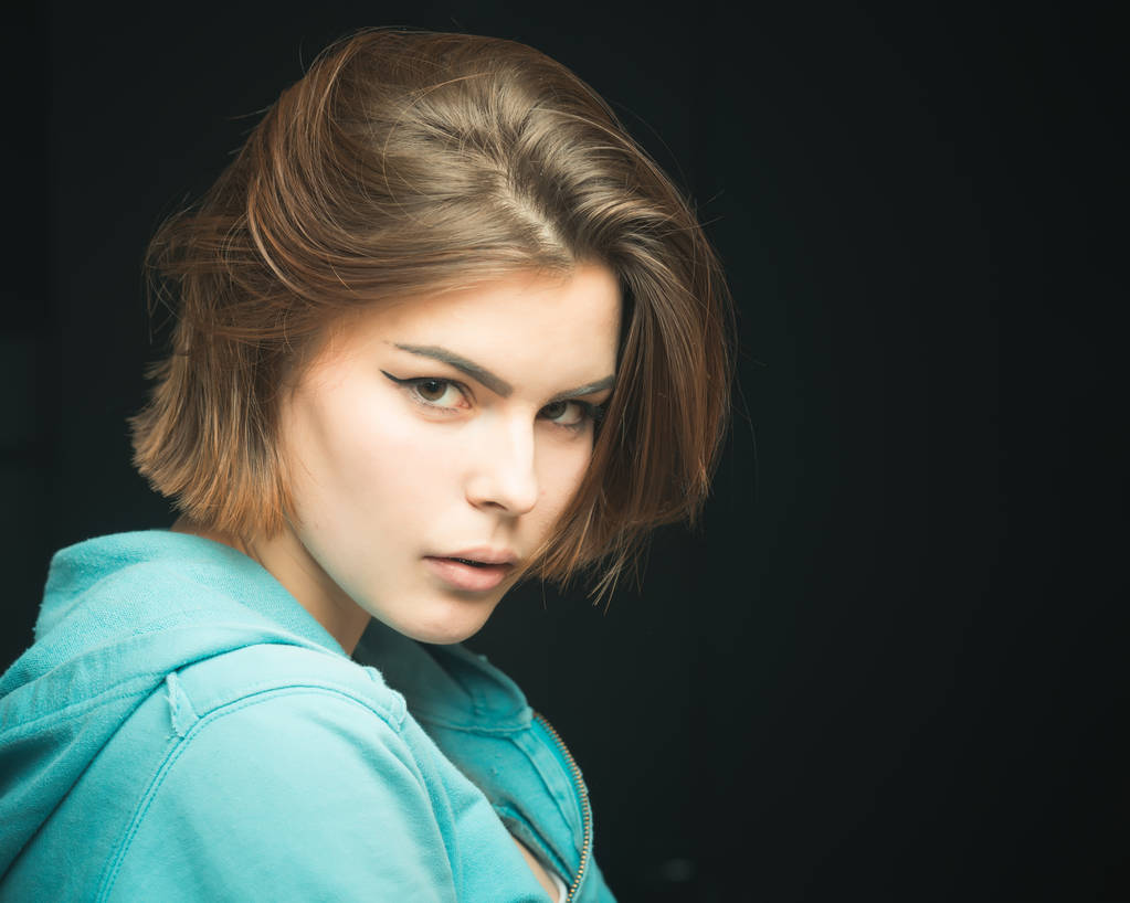 Woman on mysterious face with make up, black background. Pretty woman with hairstyle. Girl with fresh haircut, enjoying new hairstyle. Fashion shot of girl with bob haircut . Hairstyle concept. - Photo, Image