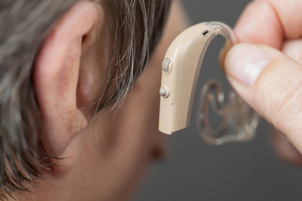 Крупним планом старша жінка з слуховим апаратом у її вусі. Охорона здоров'я, підсилення слуху, пристрій для глухих
. - Фото, зображення