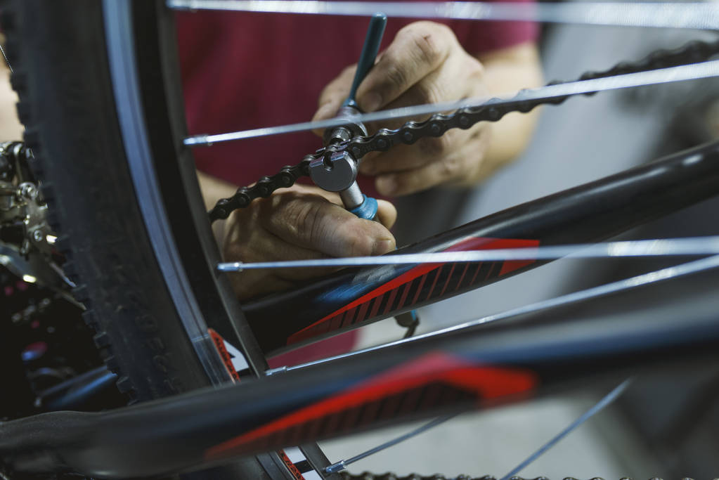 Egy kerékpárjavító üzemben rögzítése a lánc egy kerékpár szerelő. Szerelő javítás kerékpár átviteli. Kerékpárjavító üzemben és dolgozó ember szerelése a váltó, kerékpár - Fotó, kép