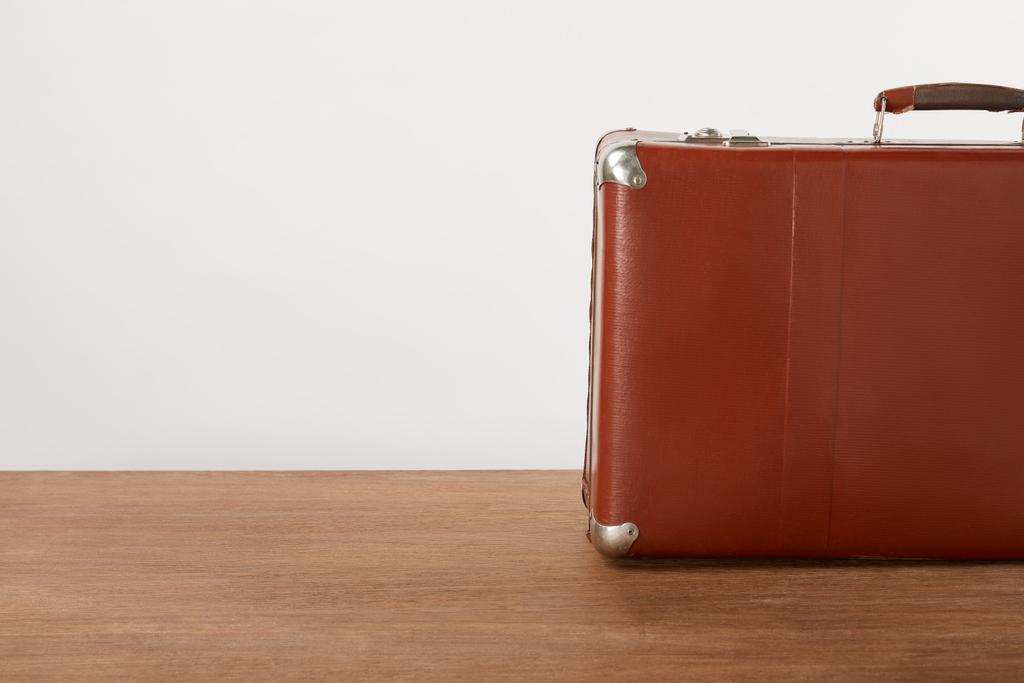 Vintage kožený kufr na dřevěný stůl bílé zdi - Fotografie, Obrázek