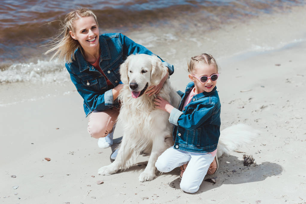 happy family with golden retriever dog on sea shore - Photo, Image