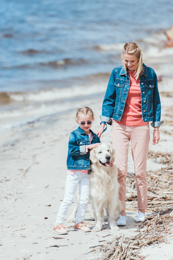 bella madre e bambino con cane a piedi vicino al mare
   - Foto, immagini