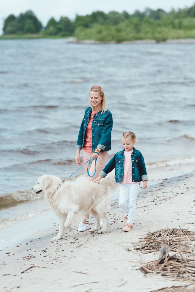 familia con perro golden retriever en paseo cerca del mar
   - Foto, imagen