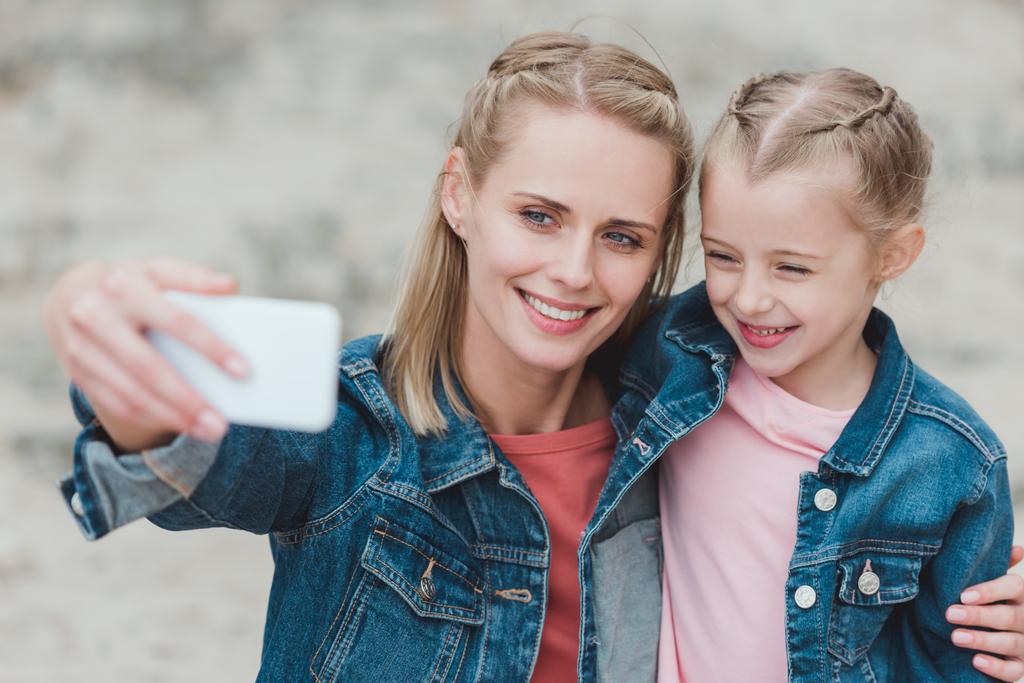 Schöne Mutter und Tochter machen Selfie auf dem Smartphone - Foto, Bild