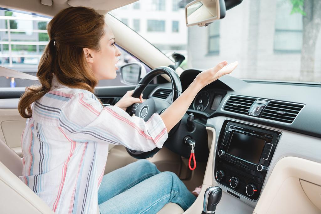 puolella näkymä emotionaalinen nainen elehtii ajaessaan autoa
 - Valokuva, kuva