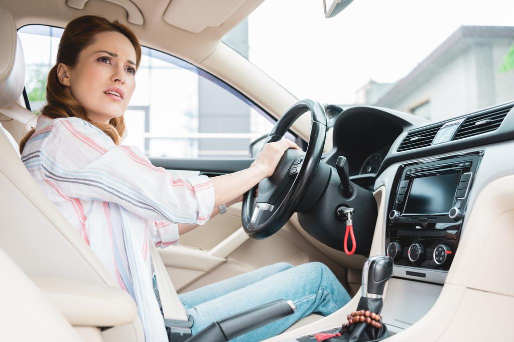 Seitenansicht einer emotionalen Frau, die während der Autofahrt hupt - Foto, Bild