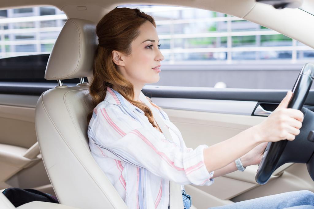 vista laterale della donna attraente guida auto da solo
 - Foto, immagini