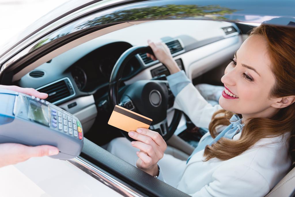 クレジット カードでお支払いになる車の笑みを浮かべて女性実業家 - 写真・画像