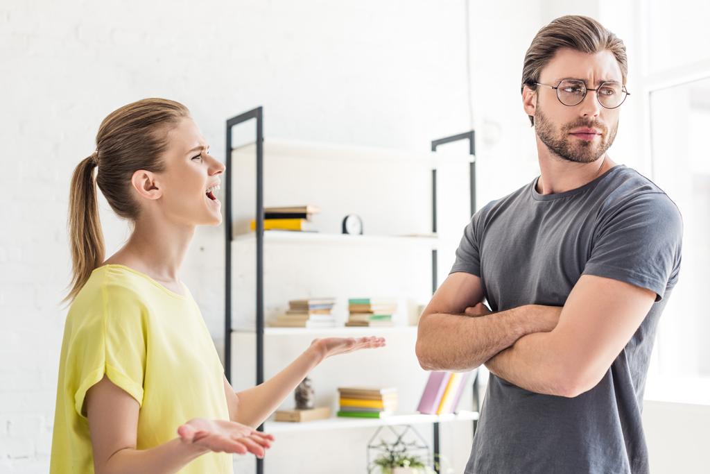 side view of woman yelling at boyfriend while she standing with cross hands
 - Фото, изображение
