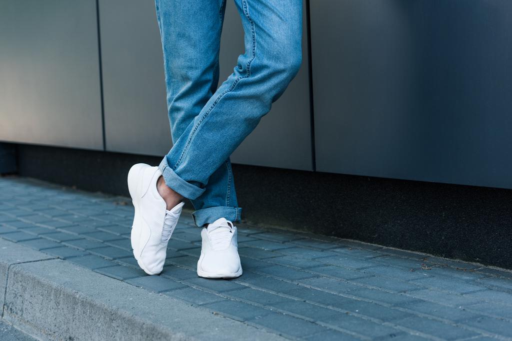 kot pantolon ve beyaz spor ayakkabı içinde şık erkek bacak resim kırpılmış  - Fotoğraf, Görsel