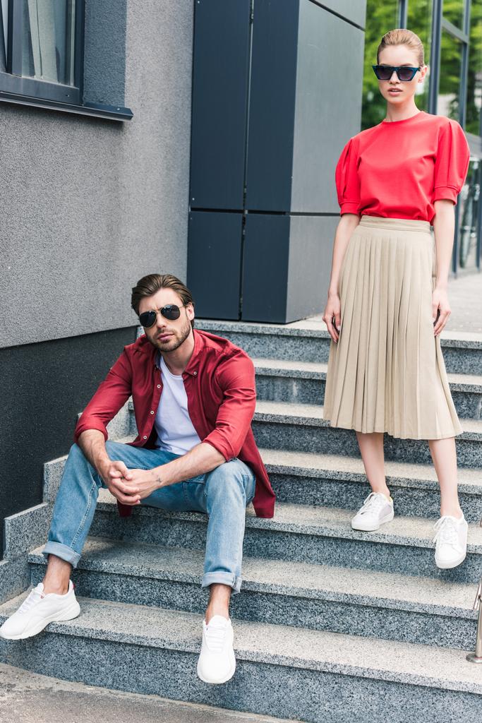 stylish young couple of models in sunglasses on stairs  - Photo, Image
