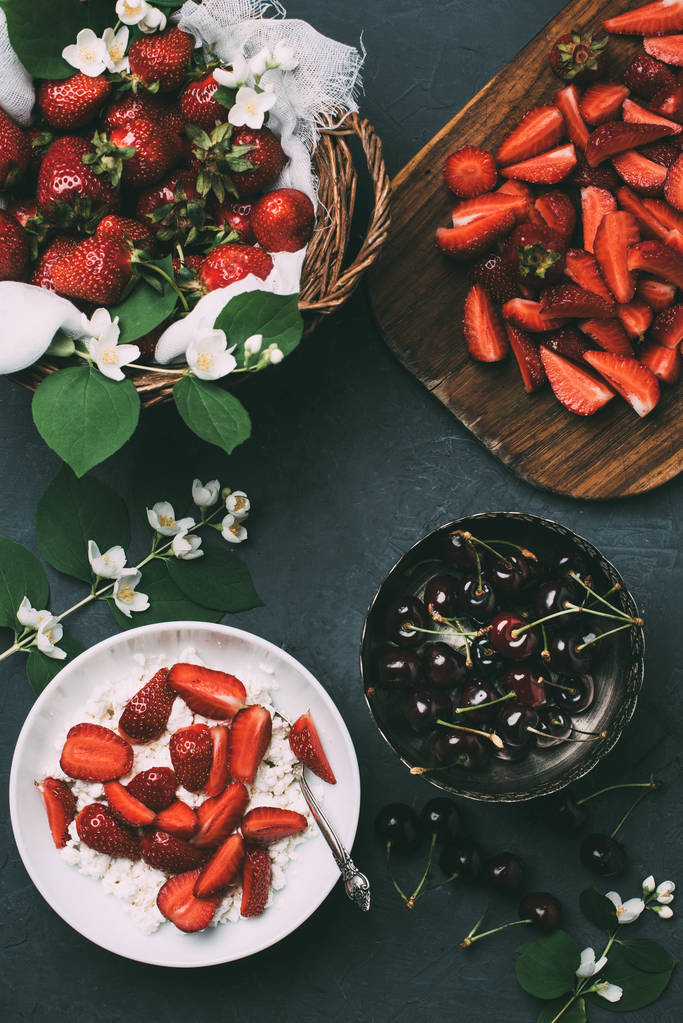 вид зверху на сир, квіти жасмину і свіжі стиглі літні ягоди на чорному
  - Фото, зображення