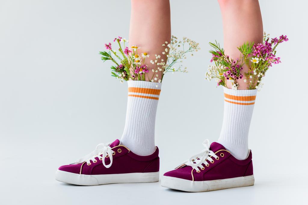 szczegół częściowy widok kobiece nogi piękne kwiaty w skarpety na białym tle na szary - Zdjęcie, obraz