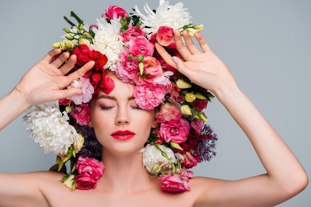 beautiful young naked woman with closed eyes posing with flowers on head isolated on grey - Photo, Image