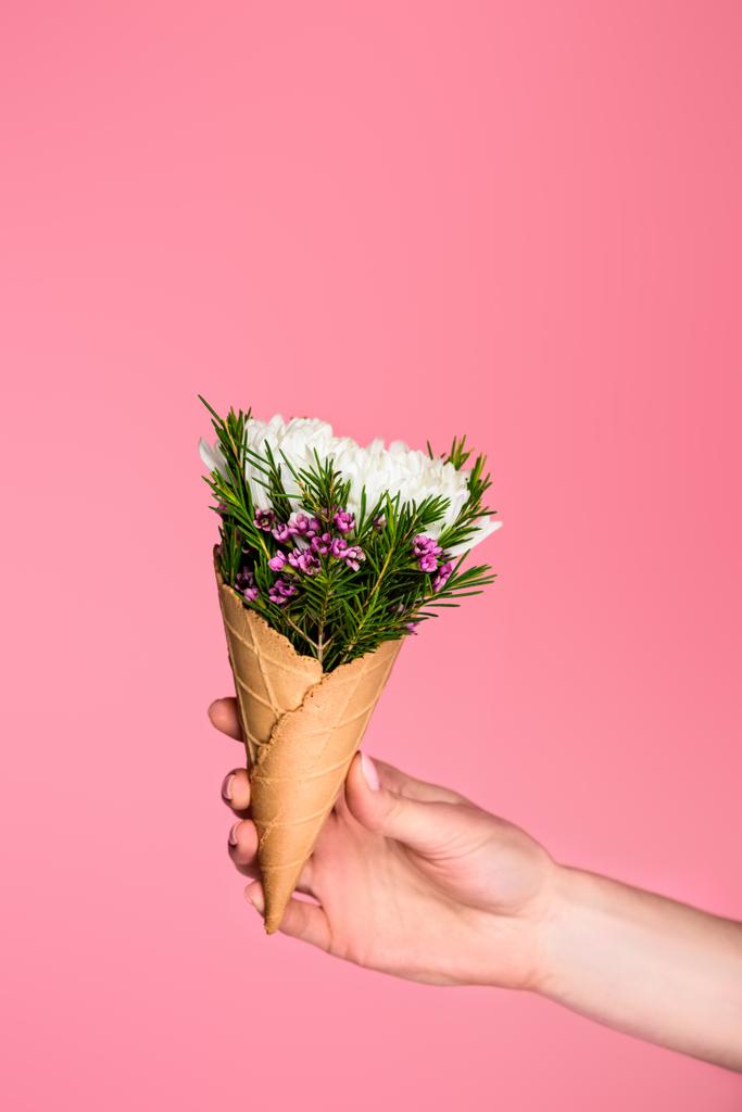 colpo ritagliato di ragazza in possesso di cono cialda con bellissimi fiori isolati su rosa
 - Foto, immagini