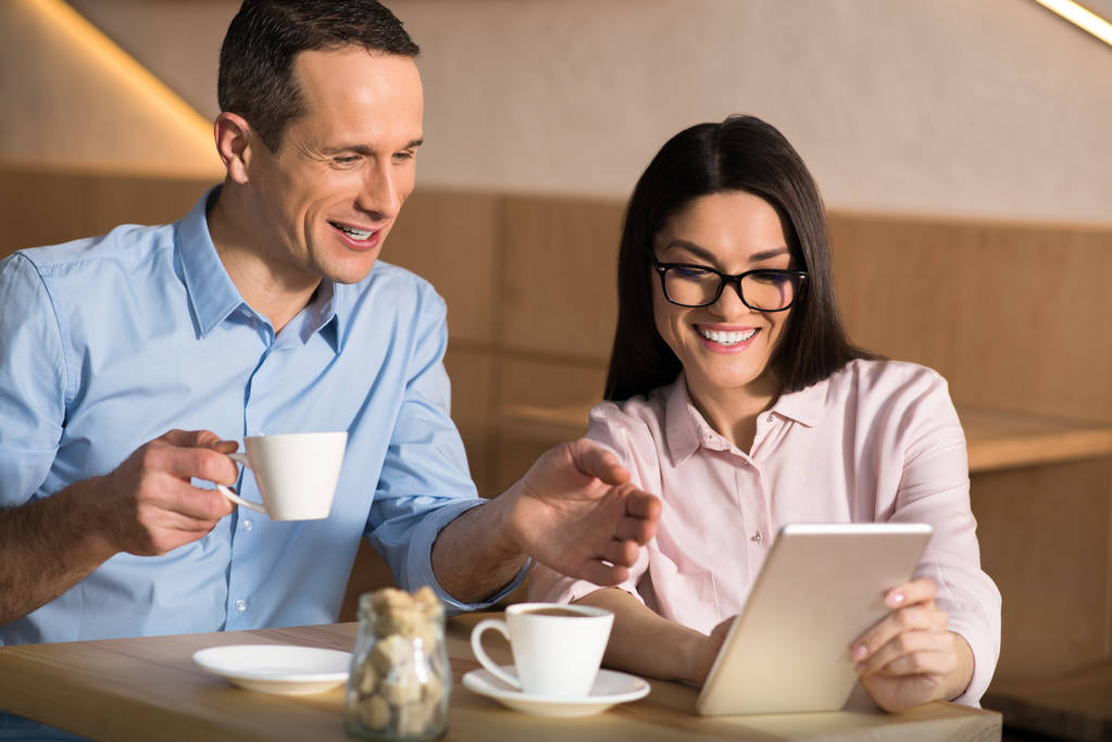 uśmiechający się kilka firm picia kawy w kawiarni i przy użyciu cyfrowego tabletu - Zdjęcie, obraz