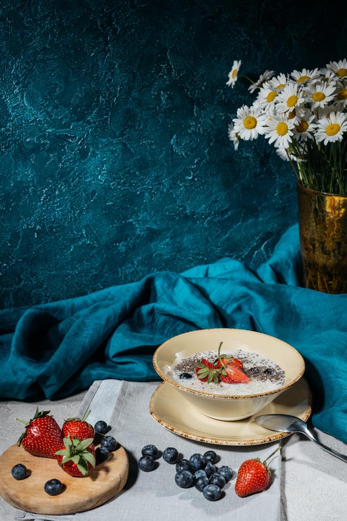 Pudim de sementes de chia em tigela com morangos e mirtilos na mesa
 - Foto, Imagem
