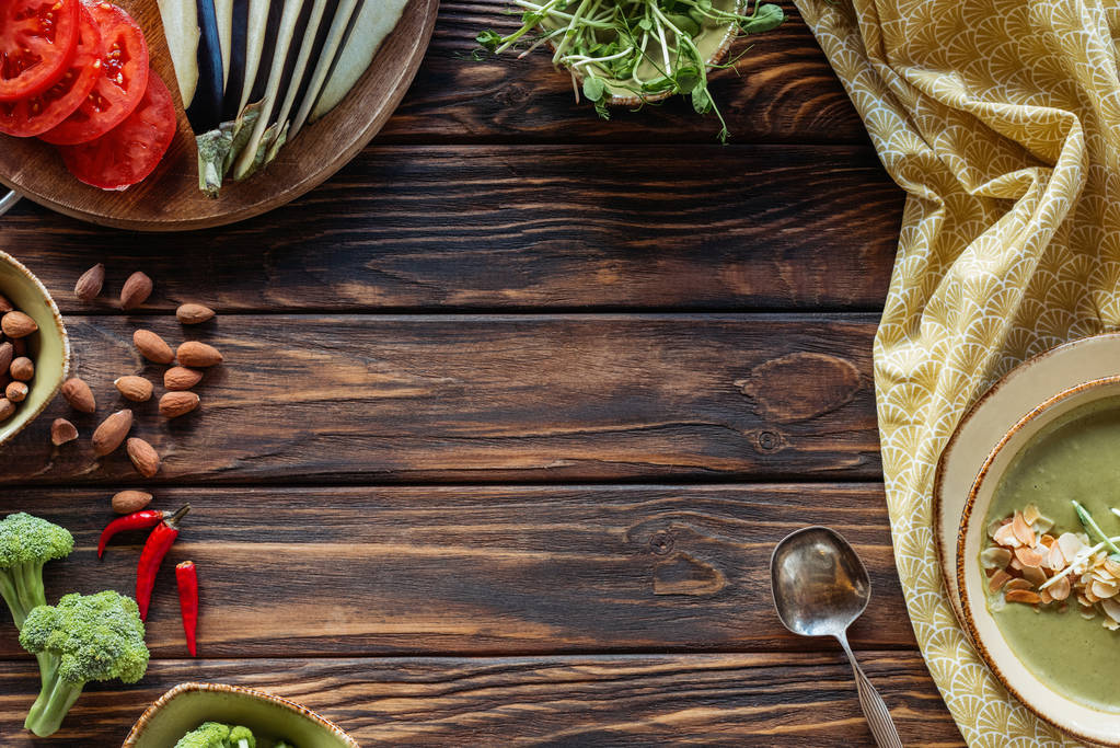 плоский лежак зі свіжими овочами та вегетаріанським вершковим супом на дерев'яній стільниці
 - Фото, зображення
