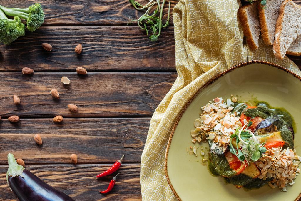 düz lay vejetaryen salata, badem, biber ve ahşap masa üstü ekmek parçaları ile - Fotoğraf, Görsel