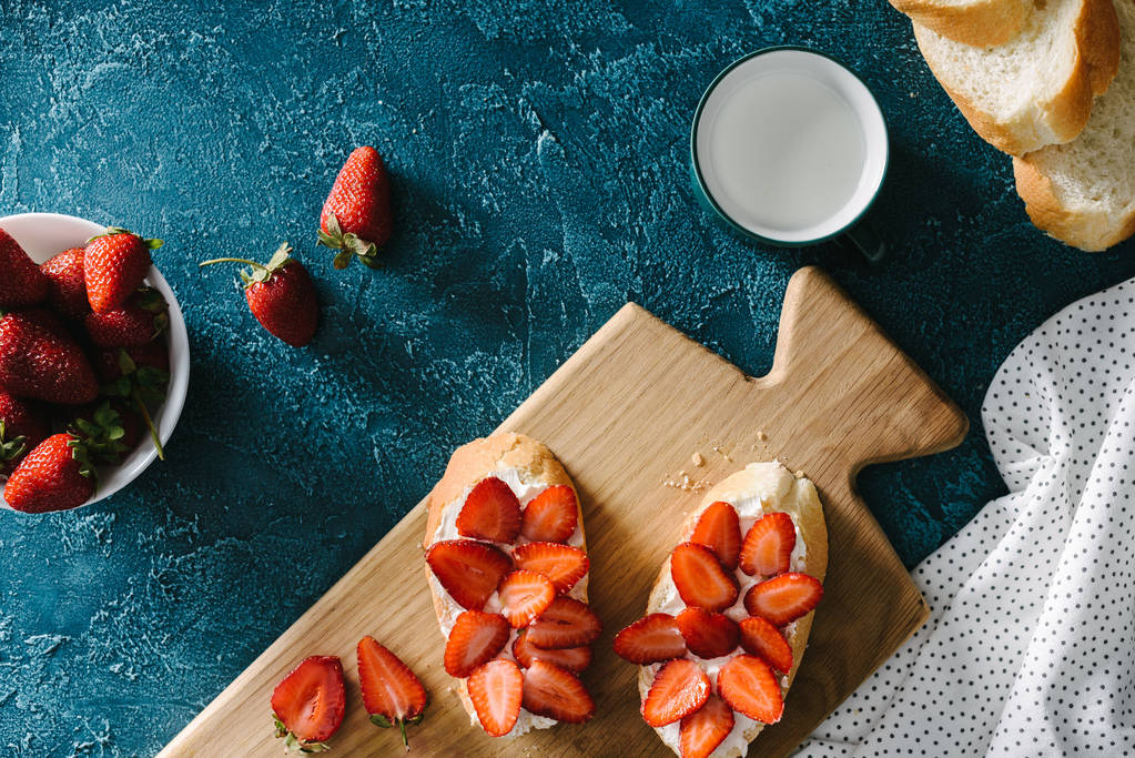 青テーブルにクリーム チーズとイチゴのトップ ビュー - 写真・画像