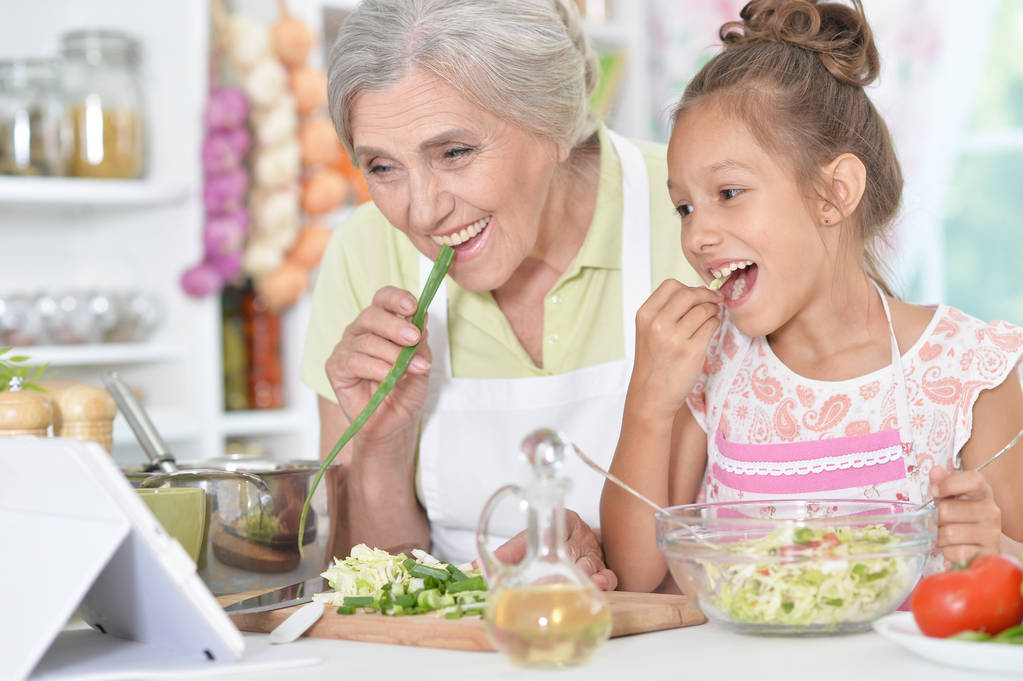 бабушка и внучка готовят ужин
  - Фото, изображение