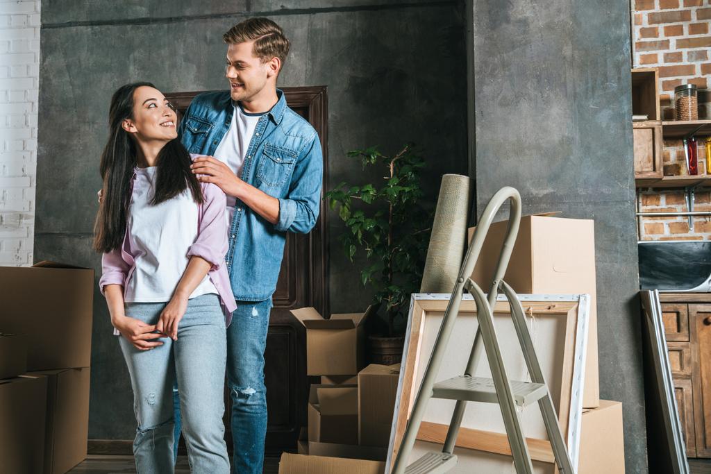 sourire couple interracial avec des boîtes déménageant dans une nouvelle maison
 - Photo, image