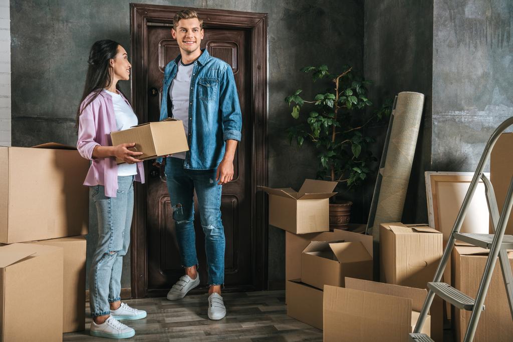 felice giovane coppia con un sacco di scatole trasferirsi in una nuova casa
 - Foto, immagini