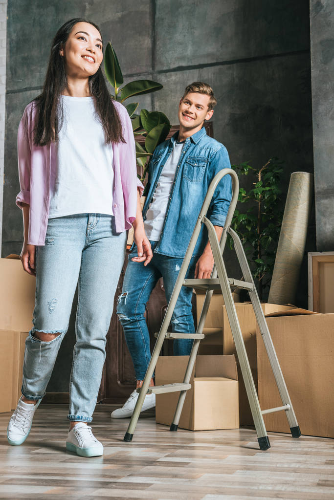 belo jovem casal com caixas e escada movendo-se para nova casa
 - Foto, Imagem